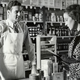 Vintage photograph of a woman reading her grocery list to the man at the counter